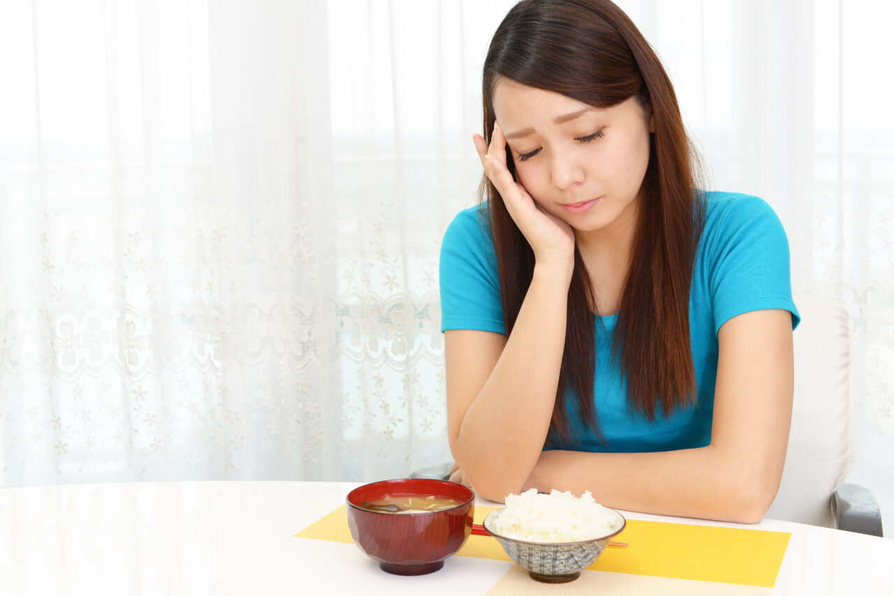 食事を前に悩むしぐさの女性