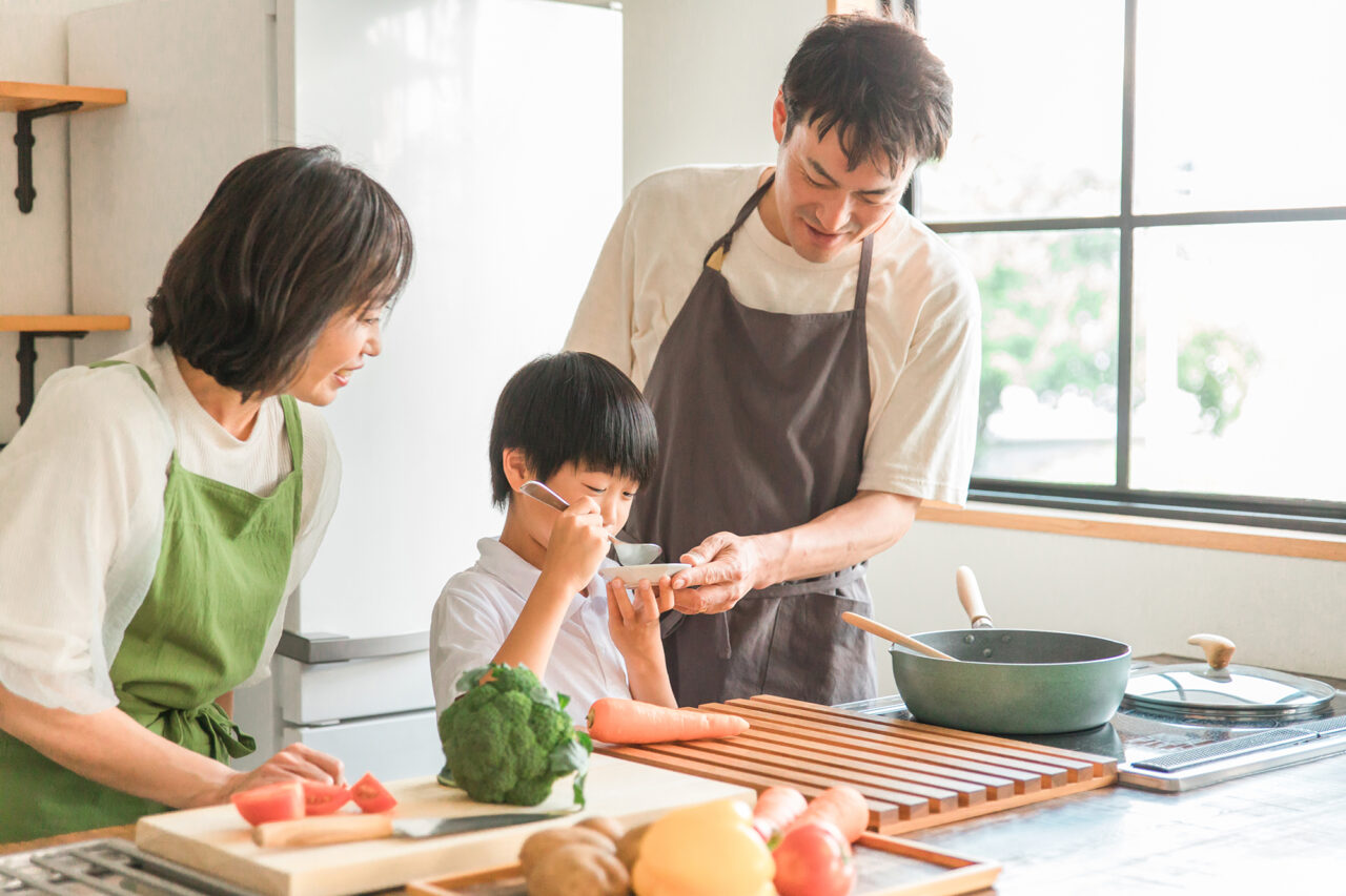 台所で調理する男女と子供